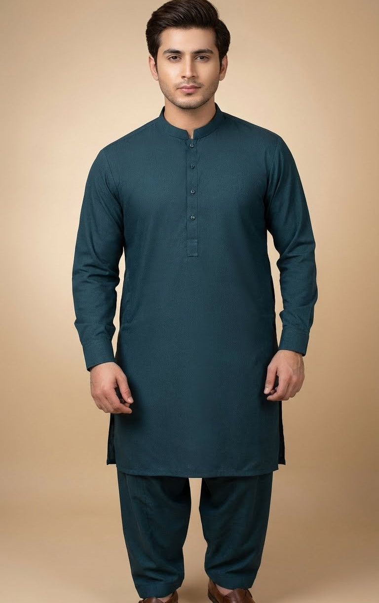 Man wearing a teal long-sleeve shirt and dark pants on a beige background