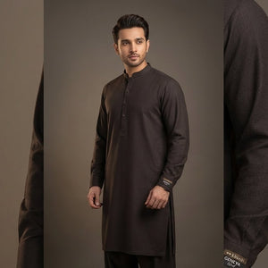 Man wearing a black kurta against a gray background