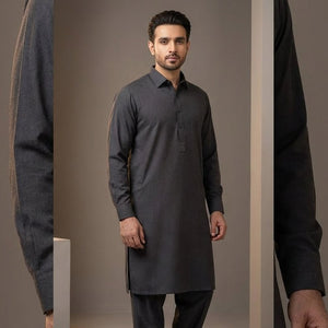 Man wearing a dark gray kurta with black pants against a plain background