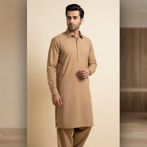 Man wearing a beige kurta in a minimalistic room.