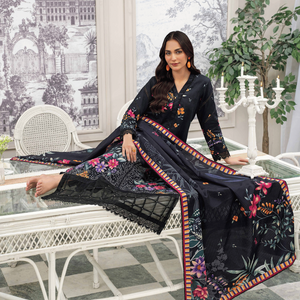 Woman in a black floral dress sitting on a white wicker chair in a decorated room.