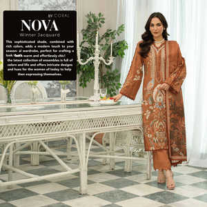 Woman in a patterned dress standing in a stylishly decorated room with white furniture and decor.