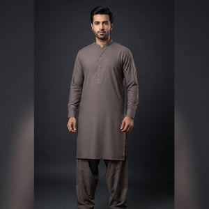 Man wearing a gray traditional outfit on a dark background