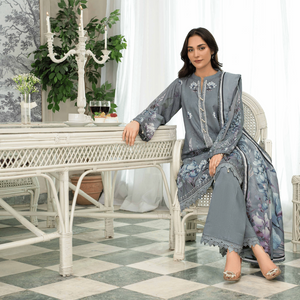 Woman in a gray and floral outfit sitting in a stylish room with white furniture and decor.