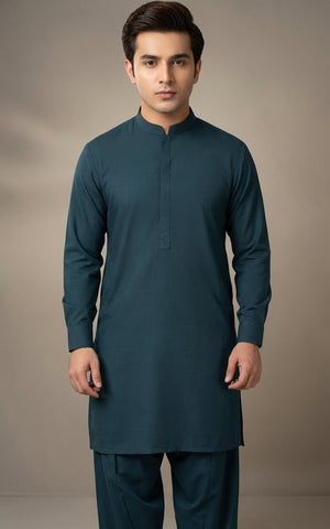 Man wearing a teal kurta with pants against a plain background