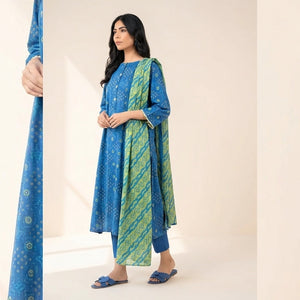 Woman wearing a blue and green traditional outfit holding a matching fabric on a plain background