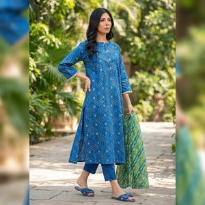 Woman in a blue dress holding a green bag outdoors