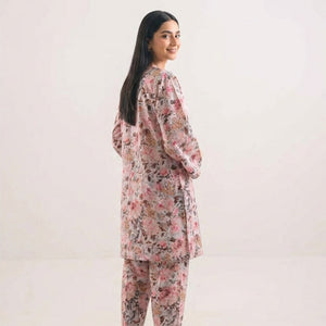 Woman wearing a floral pajama set against a plain background