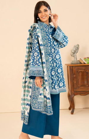 Woman wearing a blue floral traditional outfit with a matching shawl on a beige background