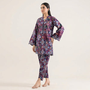 Woman wearing a patterned outfit on a plain background