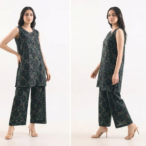 Woman modeling a black patterned outfit on a white background