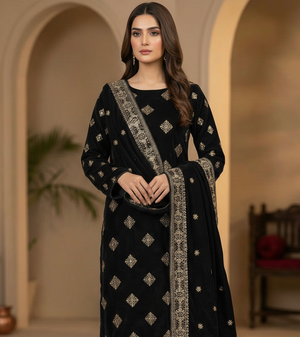Woman wearing a black embroidered traditional outfit in an indoor setting