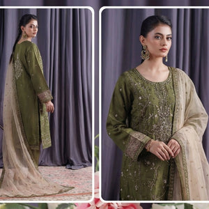 Woman in a green embroidered outfit with beige dupatta against a purple curtain background