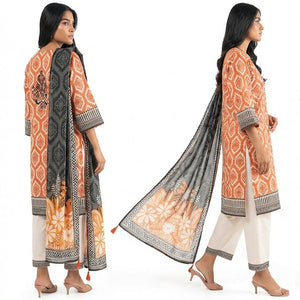 Woman modeling an orange and black patterned outfit with a scarf on a white background