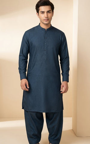 Man wearing a blue kurta with pants on a beige background