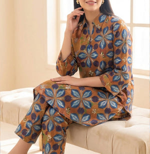 Woman sitting on a couch wearing a patterned outfit with a close-up of the fabric.