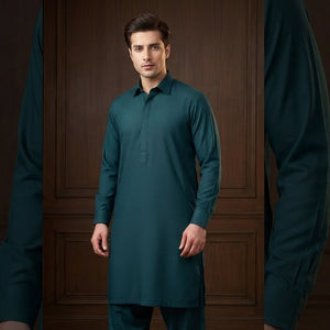 Man wearing a teal kurta against a dark wooden paneled wall