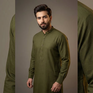 Man wearing a green traditional outfit against a gray background