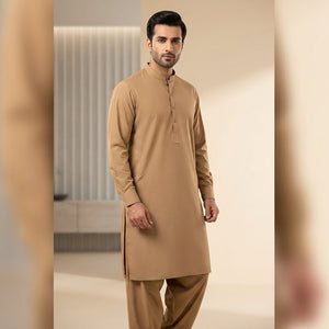 Man wearing a beige kurta in a modern interior setting