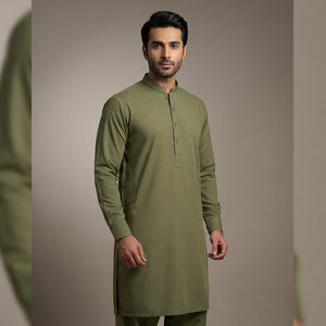 Man wearing a green kurta against a neutral background