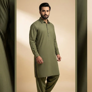 Man wearing a green kurta with pants against a beige background