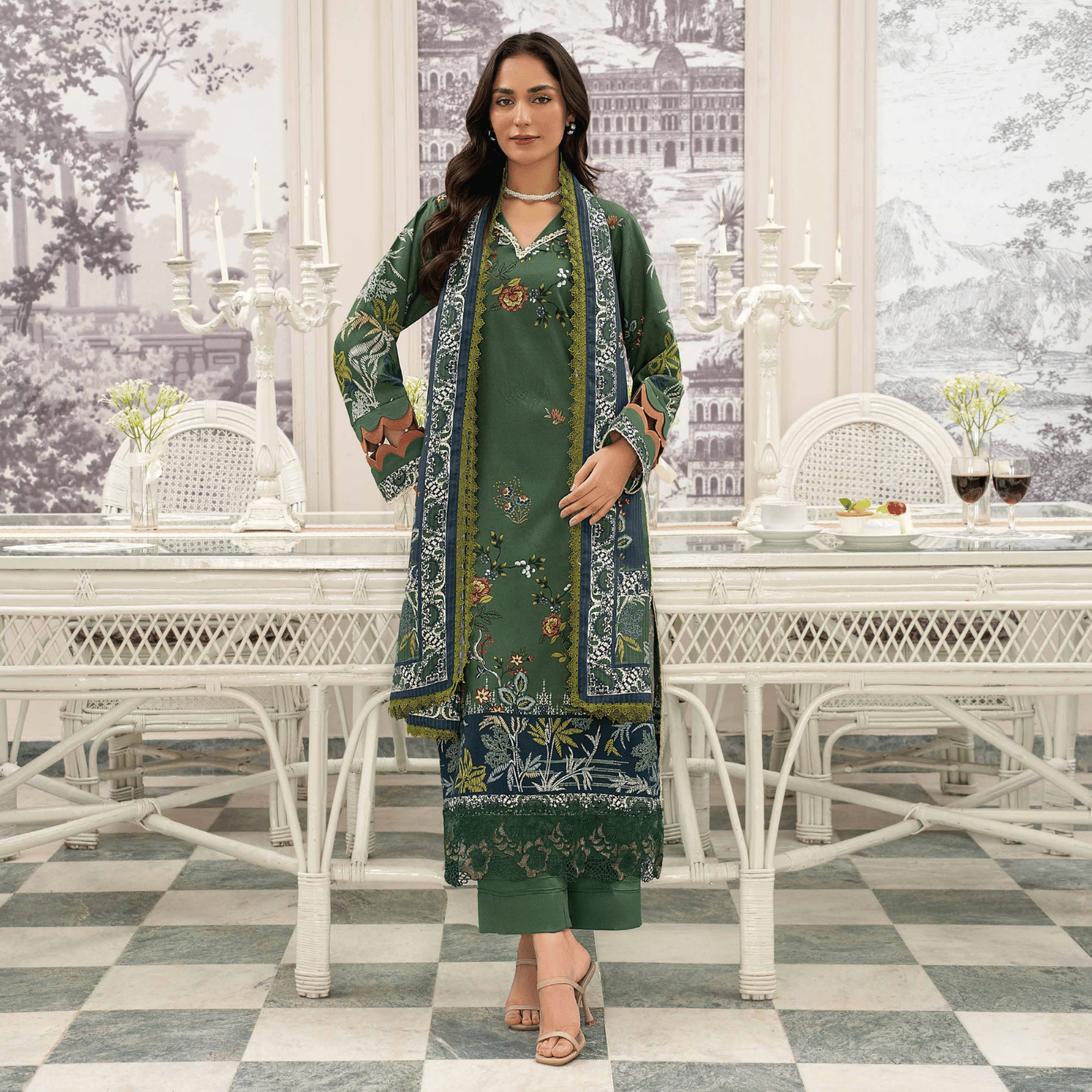 Woman in a green floral dress standing in a stylish room with white furniture and decor.