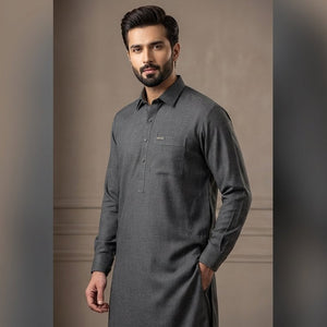 Man wearing a gray long-sleeve shirt against a neutral background