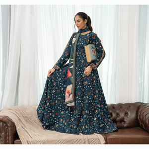 Woman in a floral dress standing in a room with a couch and lamp.