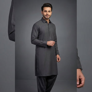 Man wearing a gray kurta with black pants on a gray background