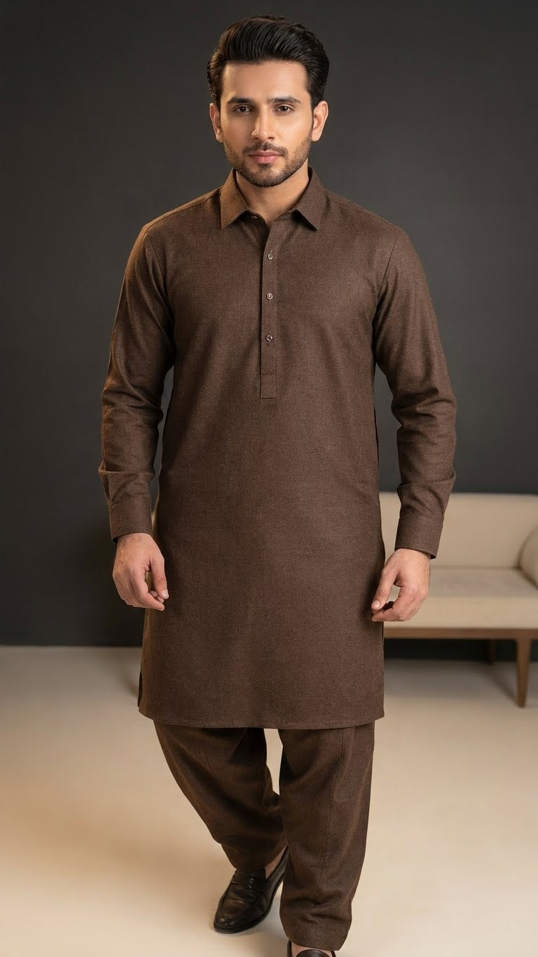 Man wearing a brown traditional outfit against a neutral background