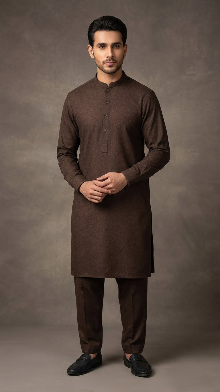 Man wearing a brown traditional outfit against a gray background