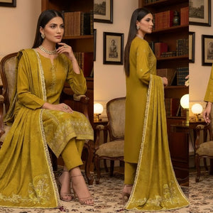 Woman in a green traditional outfit sitting in a room with bookshelves.
