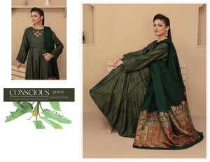 Woman wearing a green traditional outfit with floral patterns, sitting on a beige couch.