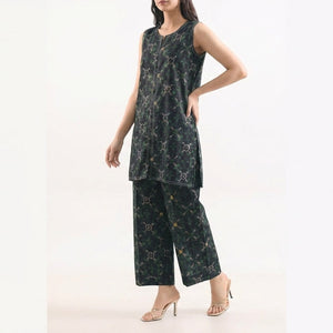 Woman wearing a black floral dress with wide-leg pants on a white background