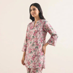 Woman wearing a floral kurta against a plain background