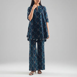 Woman wearing a blue patterned outfit with Saya branding on a white background