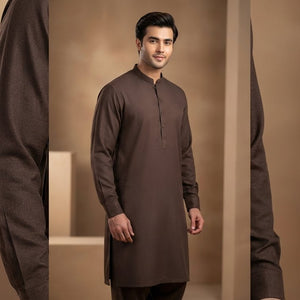 Man wearing a brown kurta standing against a beige background