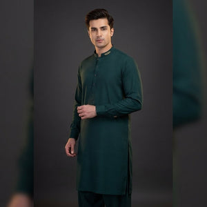 Man wearing a green kurta against a dark background
