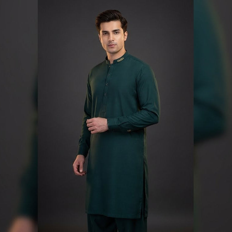 Man wearing a green kurta against a dark background