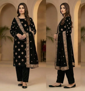 Woman in a black traditional outfit with gold embroidery in an indoor setting.