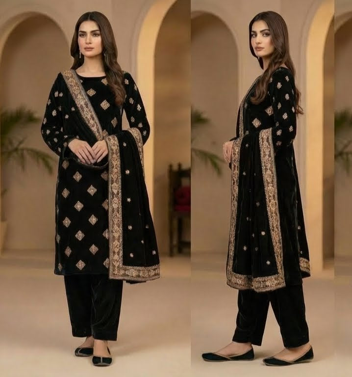 Woman in a black traditional outfit with gold embroidery in an indoor setting.