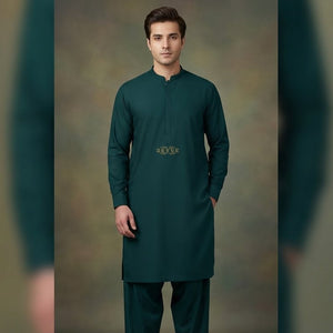 Man wearing a green traditional outfit against a neutral background