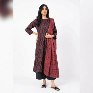 Woman wearing a patterned outfit with a scarf on a white background